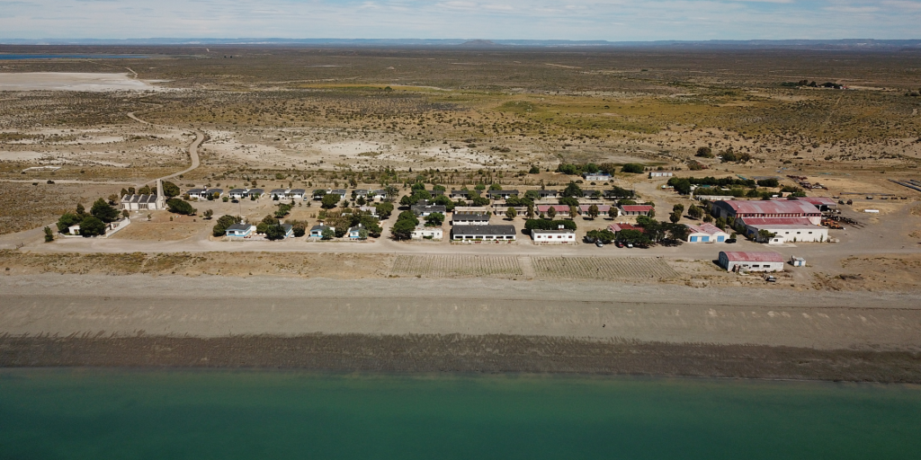 Aerial view of Bahia Bustamante Lodge, Patagonia, showing the buildings, beach, and surrounding landscape.