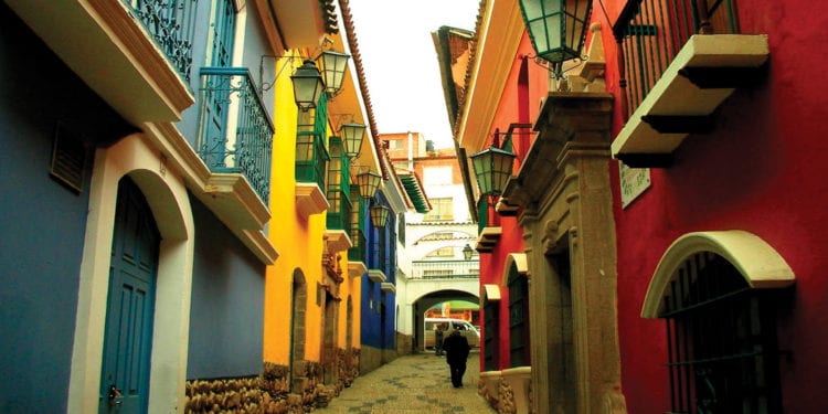 A narrow street in La Paz, Bolivia, lined with colorful buildings and adorned with lanterns.