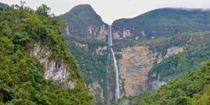 A view of the two-tiered Gocta Falls cascading down a lush green cliff face.