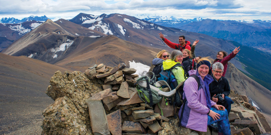 People smiling on top of the mountain in Patagonia. The w trek is one of the best treks in South America