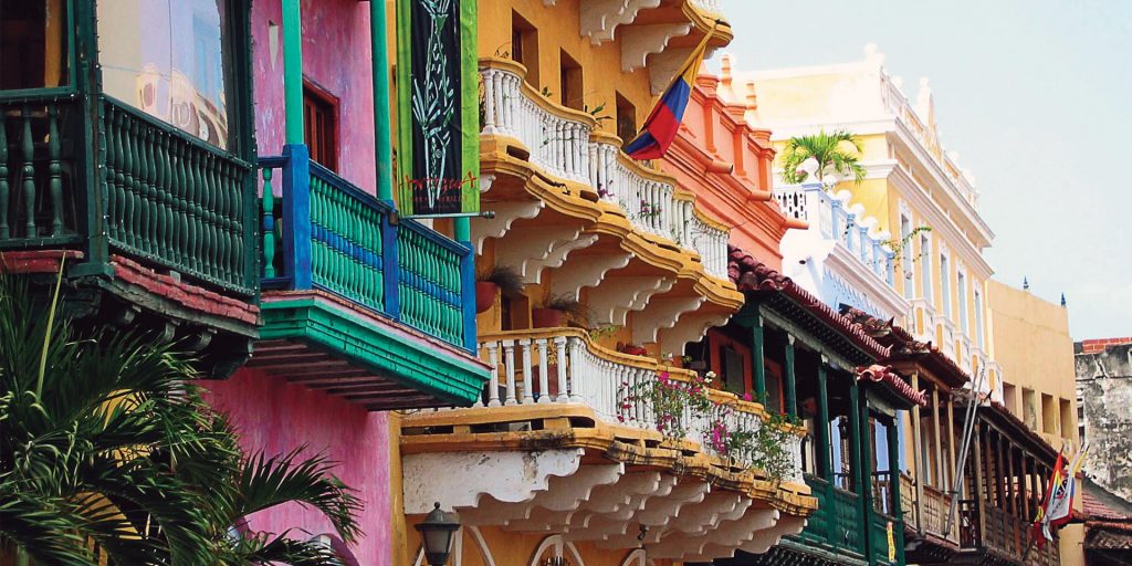 A row of colorful colonial buildings with balconies in Cartagena de Indias, Colombia.