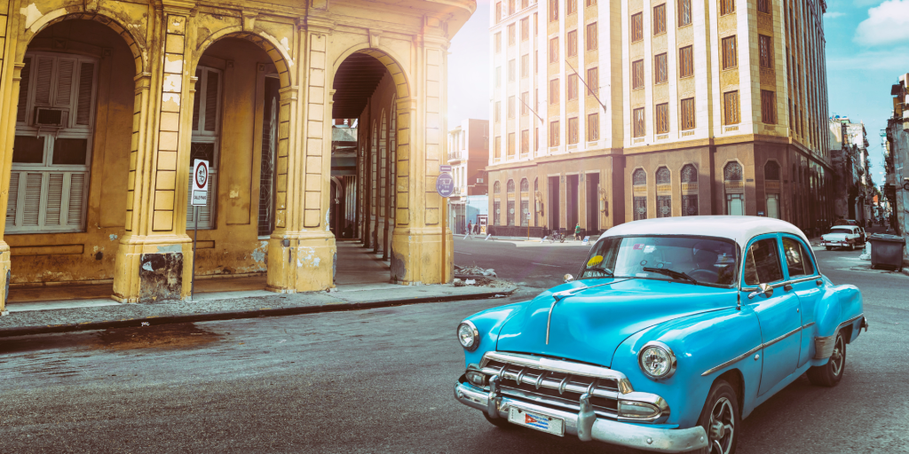 A colourful classic American cars parked on a street in Havana, Cuba, with buildings in the background.