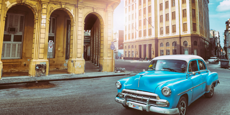 A colourful classic American cars parked on a street in Havana, Cuba, with buildings in the background.