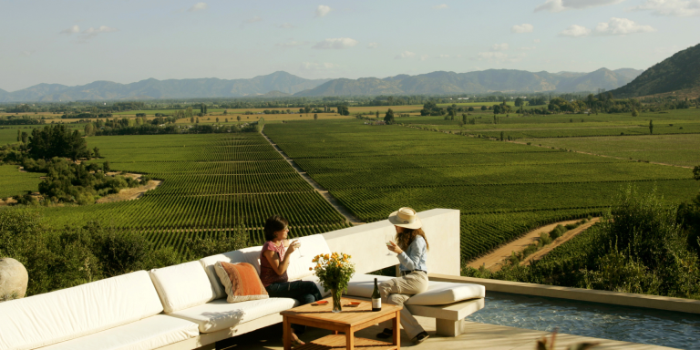 A scenic image of a two women on a terrace through a picturesque vineyard.