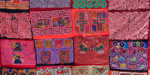 A colorful display of mola textiles with intricate geometric patterns.