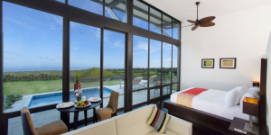 A spacious guest room with floor-to-ceiling windows overlooking the beautiful landscape of galapagos and a private plunge pool.