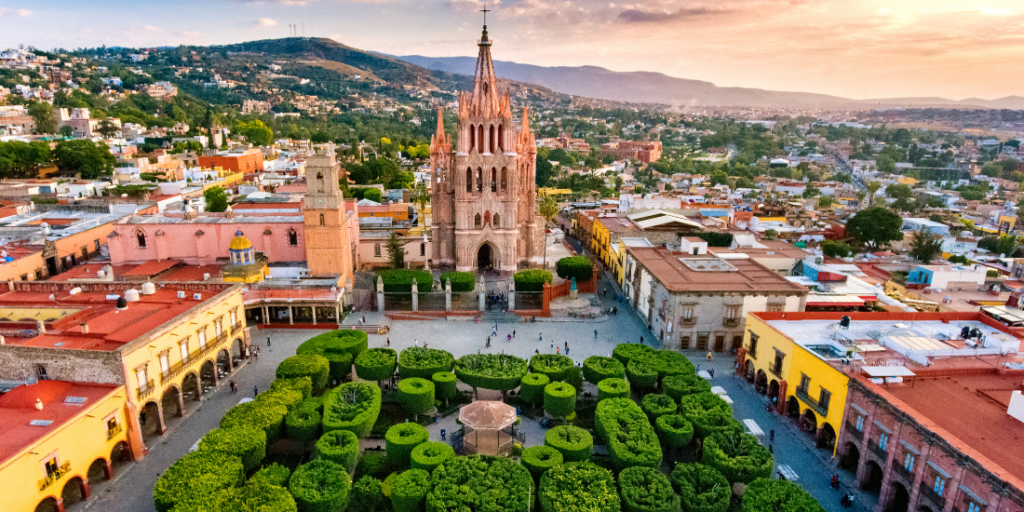 A high-angle, slightly blurred photo of the Parroquia de San Miguel Arcángel in San Miguel de Allende, Mexico.