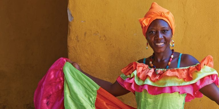 A Colombian woman with wearing a colorful traditional dress, showcasing the rich cultural heritage of Colombia.