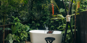 An outdoor bathtub surrounded by dense rainforest foliage.