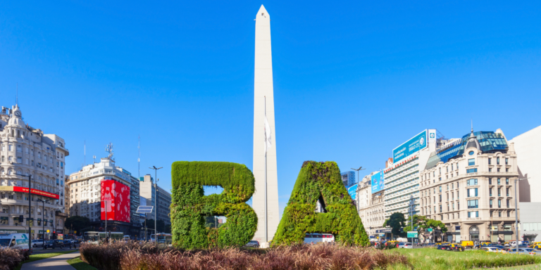The Obelisk of Buenos Aires rises above the city skyline, flanked by green "BA" letters.