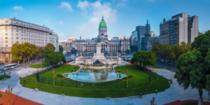The Argentine National Congress building with its distinctive green dome, overlooking a plaza with a fountain.