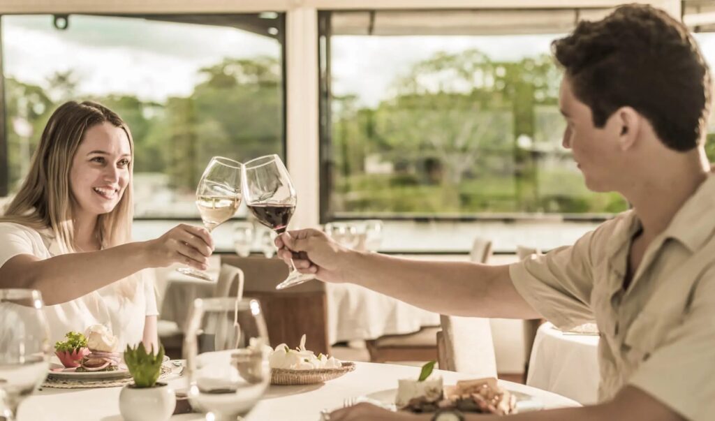 MV La Perla ship with guests in dining room on the Amazon River